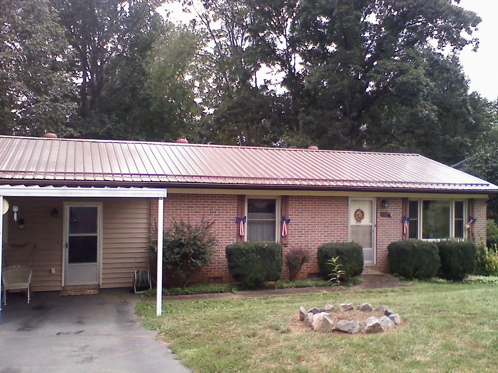 Bronze metal roof and carport on a brick ranch home — Roof Repair work by our crew in Savannah